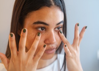 Close-up of a beauty latin young woman applying anti ageing cream to the face