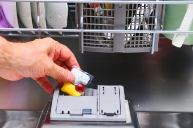 Human Hand Holding Dishwasher Tablet -