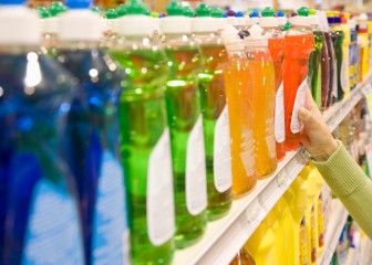 Woman selecting dishwashing liquid product in supermarket