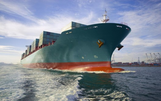 Bow view of loaded cargo ship sailing out of port