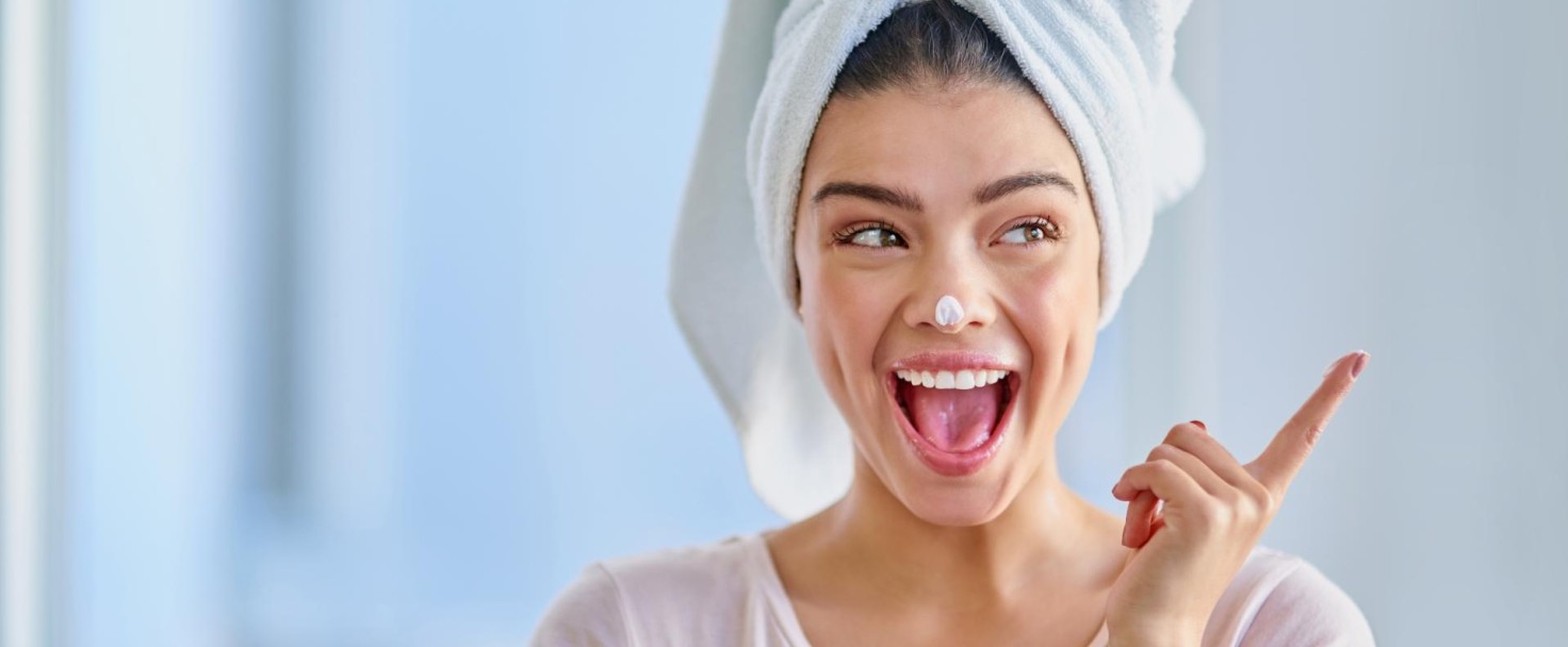Cropped shot of a beautiful young woman applying moisturizer to her skin in the bathroom at home