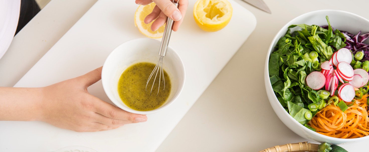 Young woman preparing a fresh salad dressing, Germany