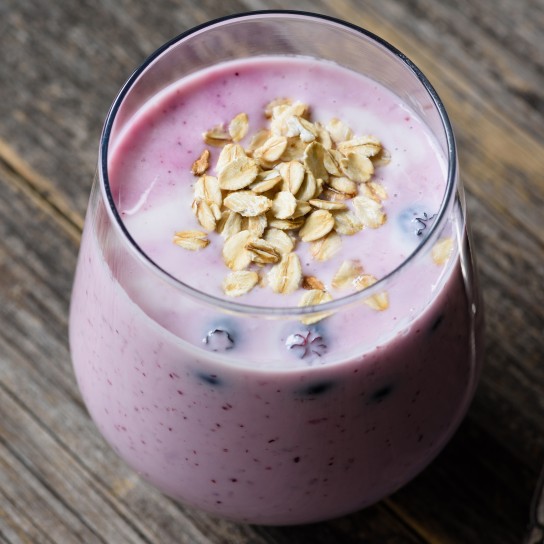 Blueberry smoothie with oats in glass on wooden table. Healthy eating, healthy lifestyle, dieting concept