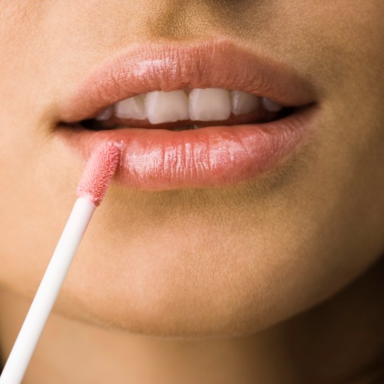 Woman applying lip gloss