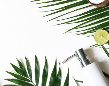 Cosmetic bottle with green herbal leaves,