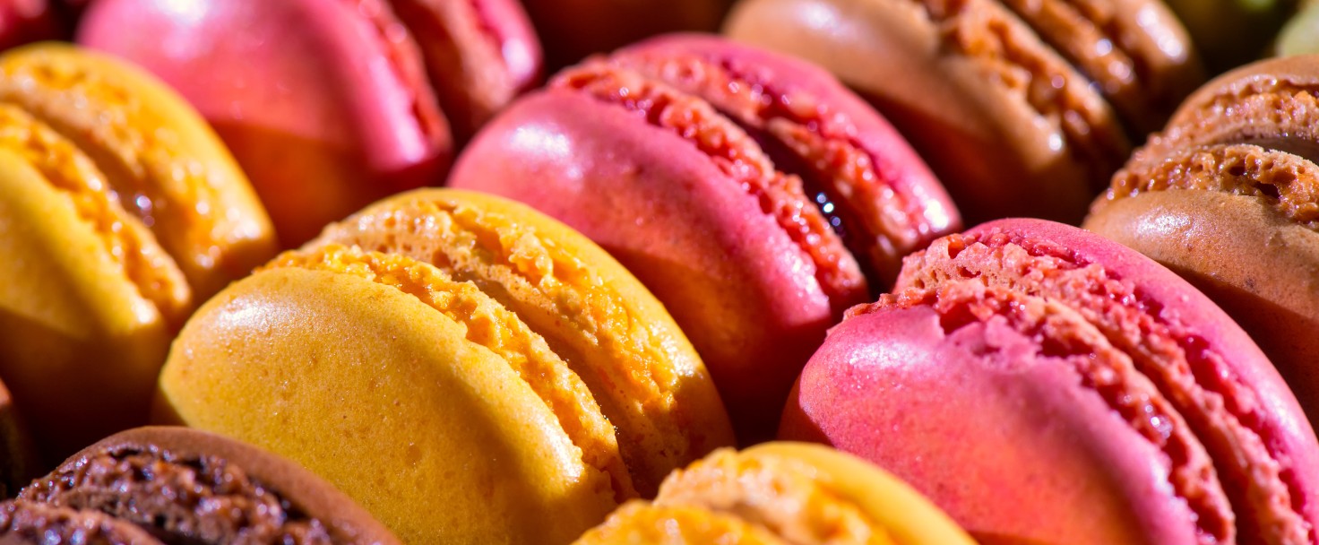 A bunch of colorful pastel macaroons in a row.