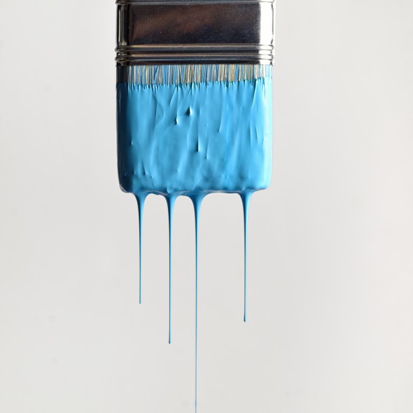 Close-Up Of Blue Paint Dripping Into Container Against Wall