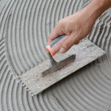 Hand on be bound with cement , do cement work, apply cement (over a surface)