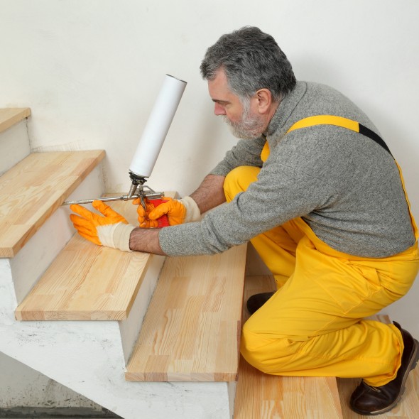 Home renovation, wooden stairs fix with polyurethane spray gun