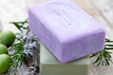 body cream on purple bath towel
