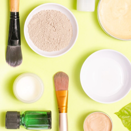 Top view of different cosmetics products on yellow background