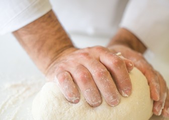 Cropped Hands Kneading Dough On Kitchen Counter