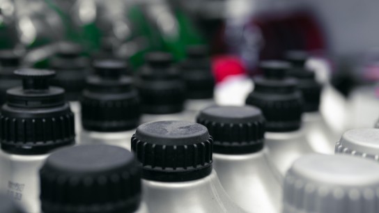 A large number of plastic bottles for motor oil. The covers are close. selective focus