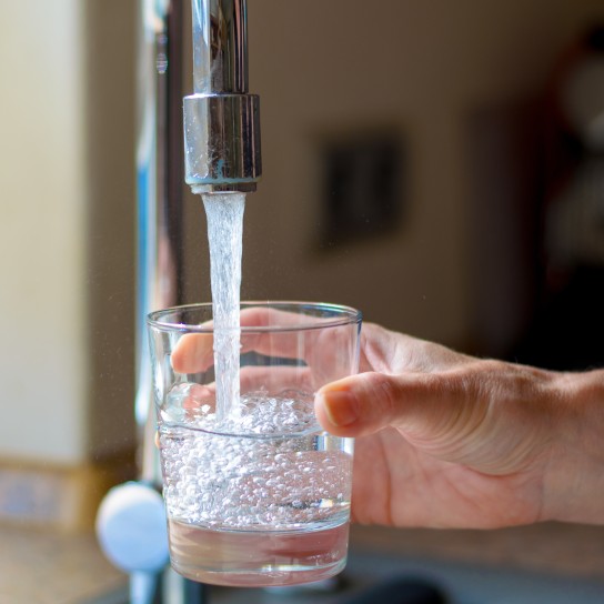 Cropped Hand Filling Glass With Water From Faucet