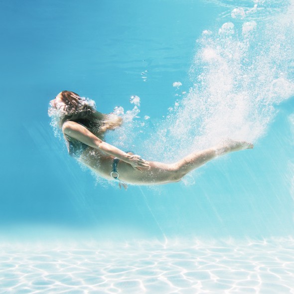 Woman swimming underwater in swimming pool