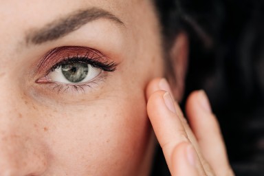 Portrait of beautiful woman with gray eyes, freckles and candid smile. Her fingers are touching her skin. Concept of natural beauty and care. Close-up of half of the face
GettyImages-2171430840.jpg