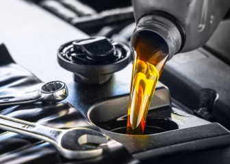 Pouring motor oil for motor vehicles from a gray bottle into the engine