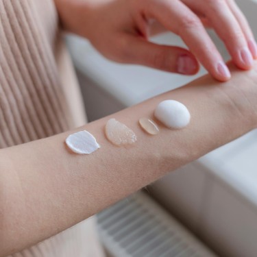 Different textured skin care products on woman's hand.
GettyImages-1465659006.jpg