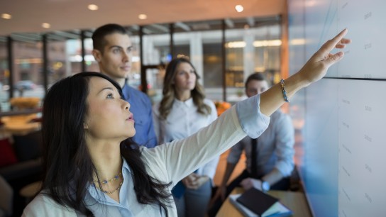 Business people pointing at projection screen