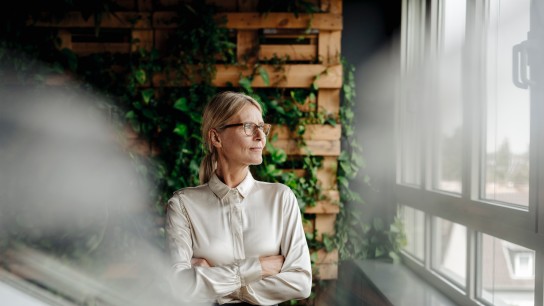 Businesswoman in green office looking out of window