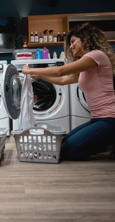 Couple doing laundry together in front of washing machine