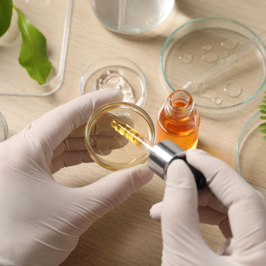 Scientist making cosmetic product at wooden table, above view