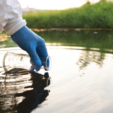 Environment engineer Collect samples of wastewater from industrial canals in test tube, Close up hand with glove Collect samples of wastewater from industrial canals in test tube. mobile water laboratory check