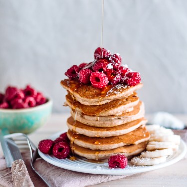 American pancakes with raspberry, banana and maple syrup