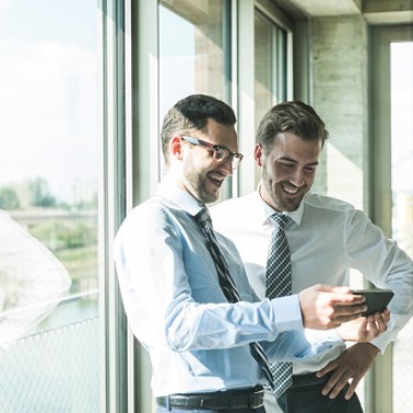 Two young businessmen looking at documents