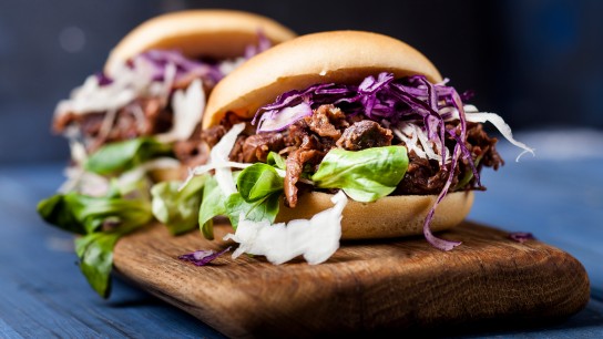 Zdravý veganský jackfruit burger s červeným a bílým zelím a kozlíčkem polním
