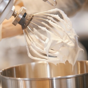 Process of cooking meringue whipped egg whites on mixer whisk , close up
GettyImages-876000170.jpg