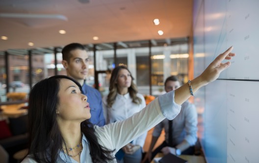 Business people pointing at projection screen
