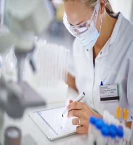 Woman in a lab making notes for her thesis