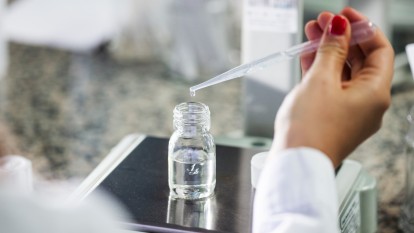 Chemiczka analizuje wynik testu w szklanej tubie