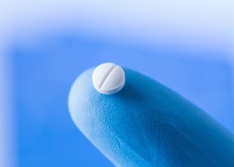 Small pill at the tip of a scientist finger in gloves, medical research concept
GettyImages-1020067918.jpg