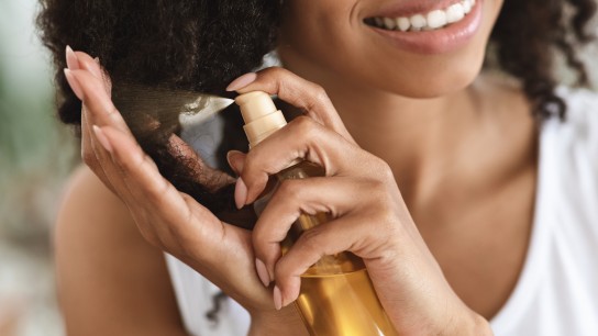 Split Ends Repair Treatment. Smiling African Woman Applying Essential Oil Spray On Her Curly Brown Hair At Home, Cropped Image, Closeup
GettyImages-1227501321.jpg