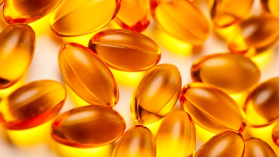 A smiling young woman holding a bottle