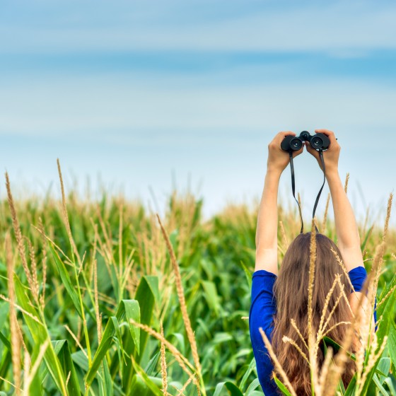 Woman holding a binocular in a field