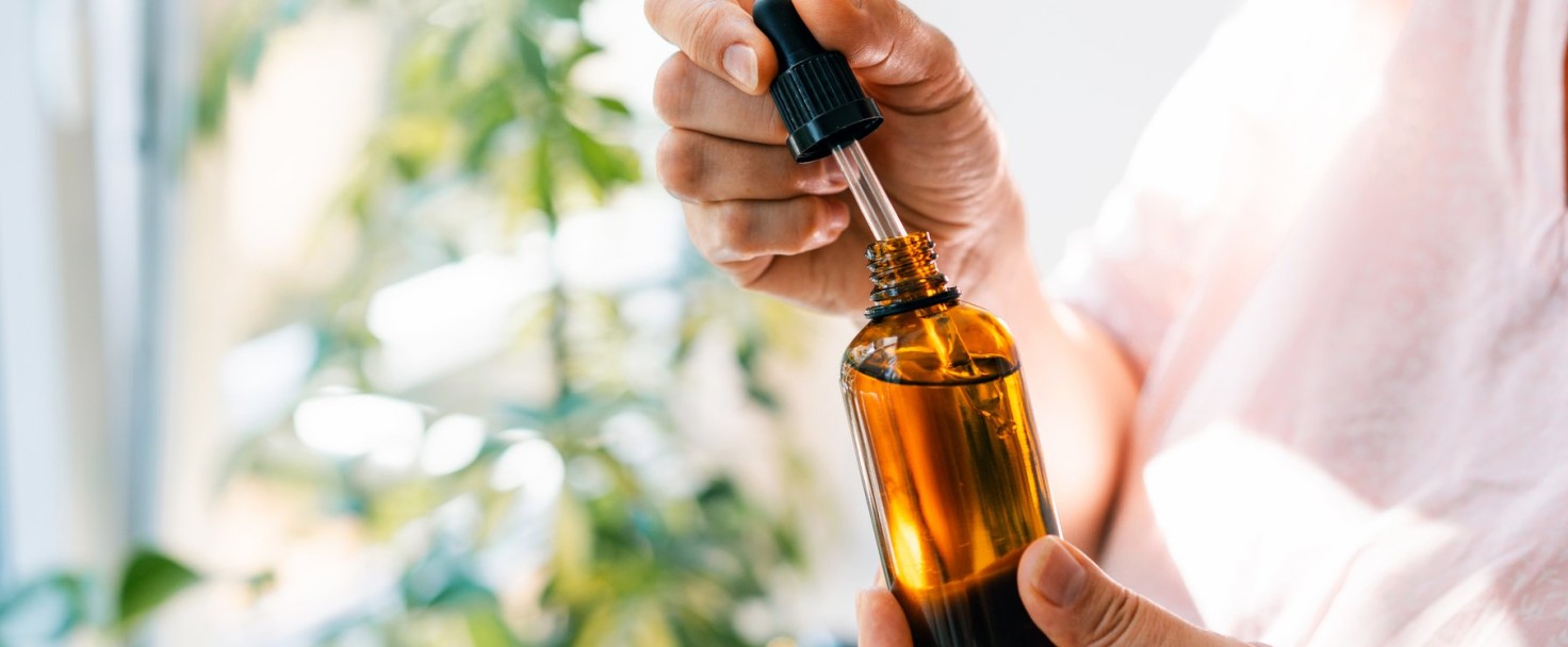 Woman holds pipette and amber glass bottle with natural essential oil or organic serum. Body care concept
GettyImages-2168214960.jpg