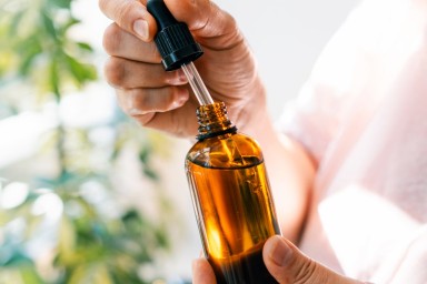 Woman holds pipette and amber glass bottle with natural essential oil or organic serum. Body care concept
GettyImages-2168214960.jpg